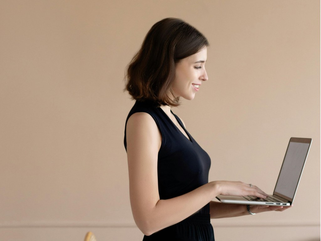 Woman standing up and working on her computer