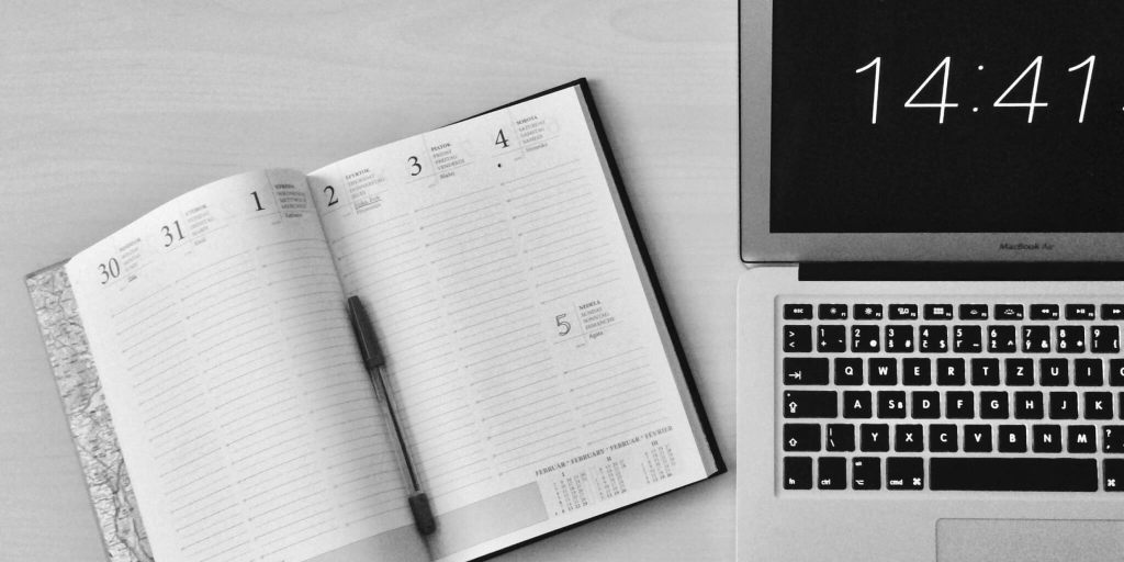 a work station with a laptop and a planner